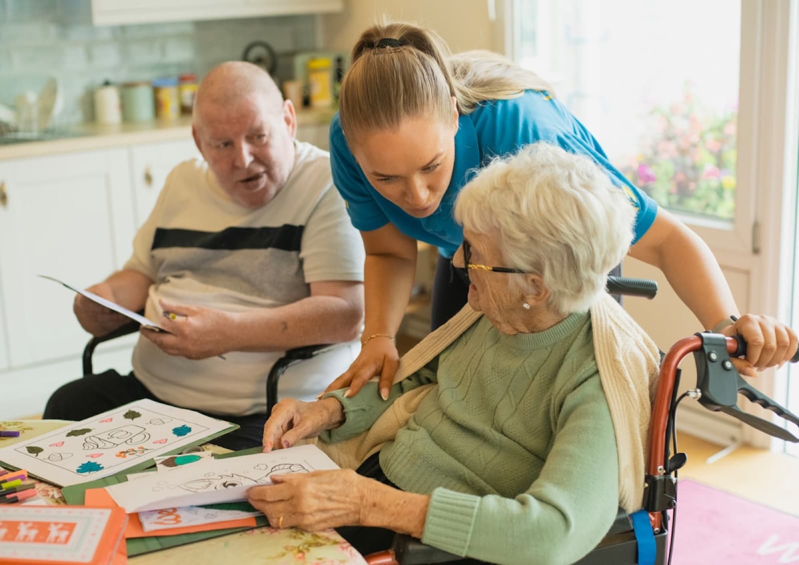 A caregiver gently helping an older adult with a tabletop activity