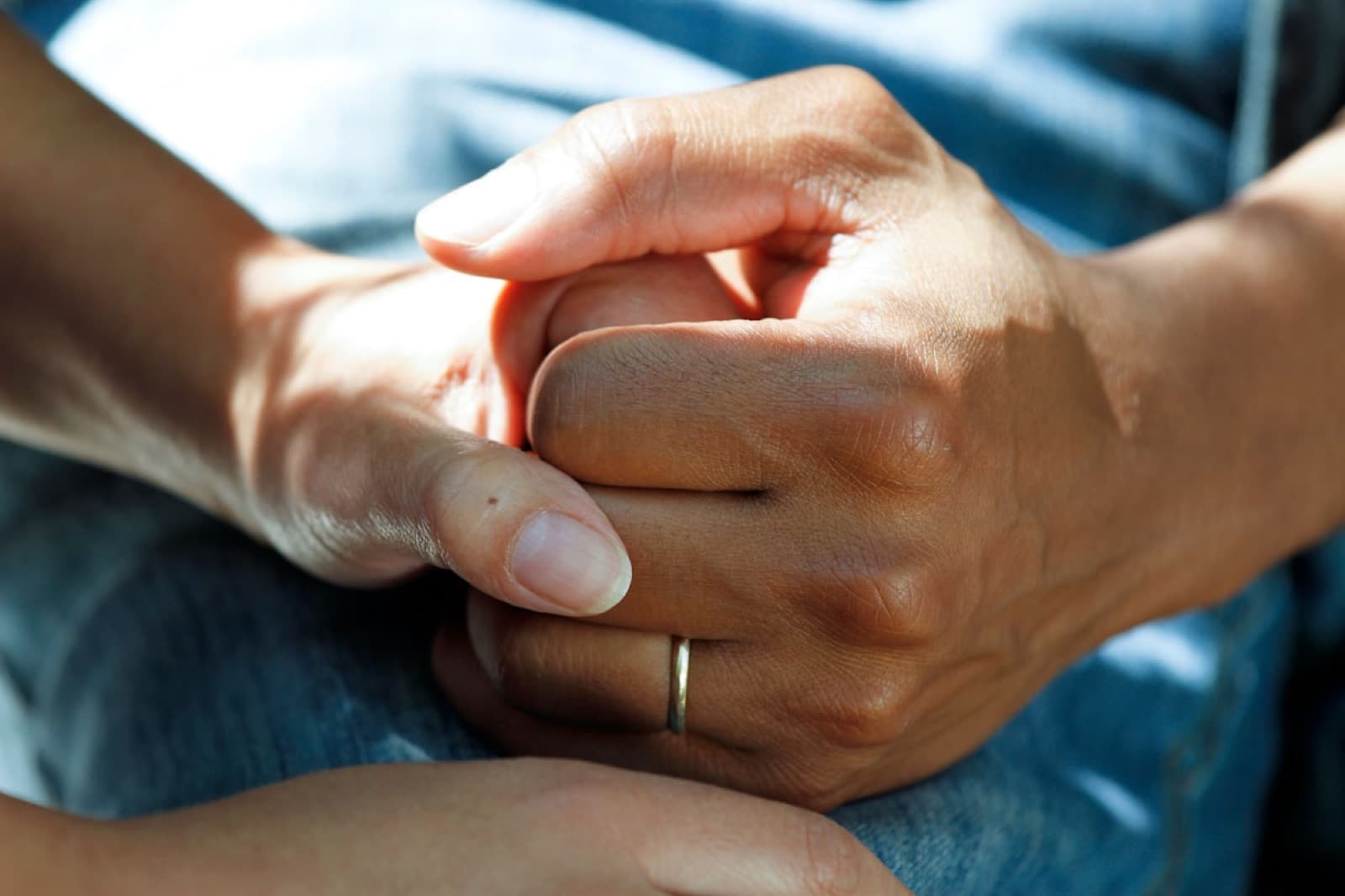 Two people holding hands in a gesture of comfort and support